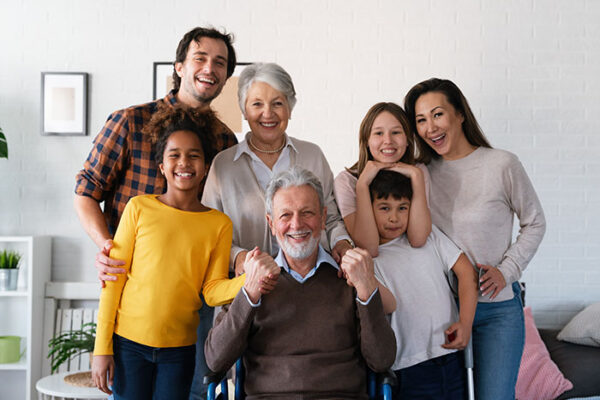 Extended happy family Generations portrait at home with handicapped senior
