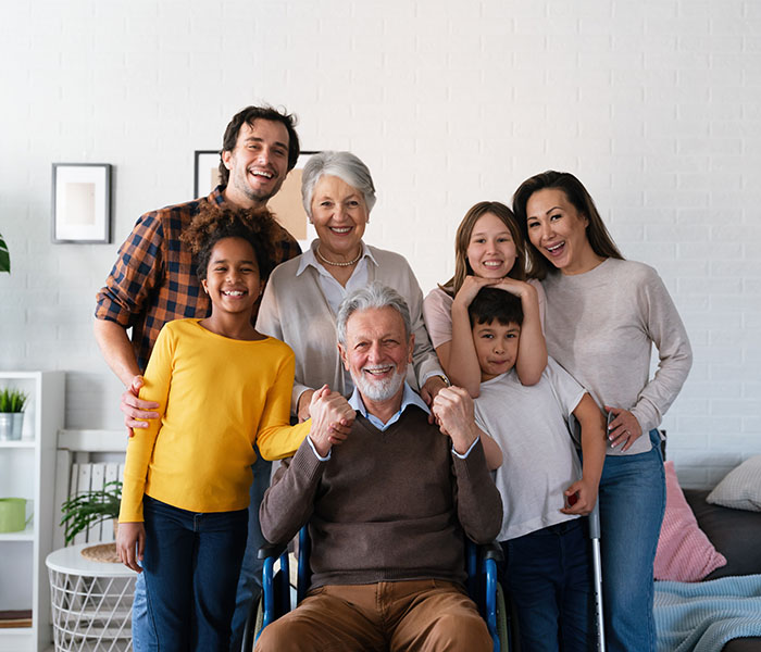 Extended happy family Generations portrait at home with handicapped senior
