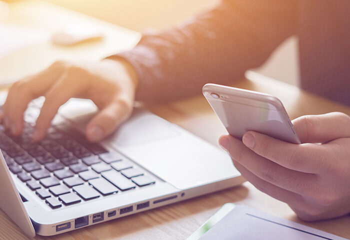 person working on laptop and phone