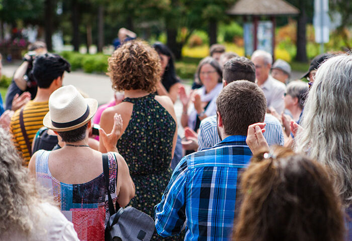People at an outdoor event clapping