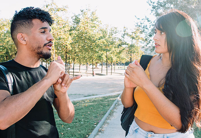 2 hispanic students signing to each other in ASL