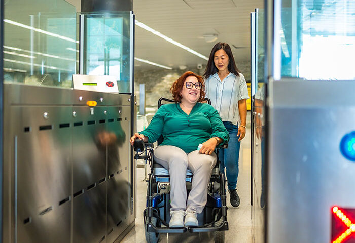 Woman in a wheelchair and caregiver exiting the metro doors